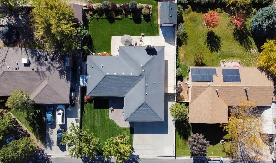 Drone view of neighbourhood roofs, some with solar panels